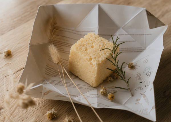 Panetto di shampoo solido 43 Grani Ethical Grace aperto nella confezione origami in carta, con fiori di camomilla essiccati