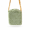 Panetto verde chiaro di Scacciaguai appeso alla rafia su sfondo bianco.